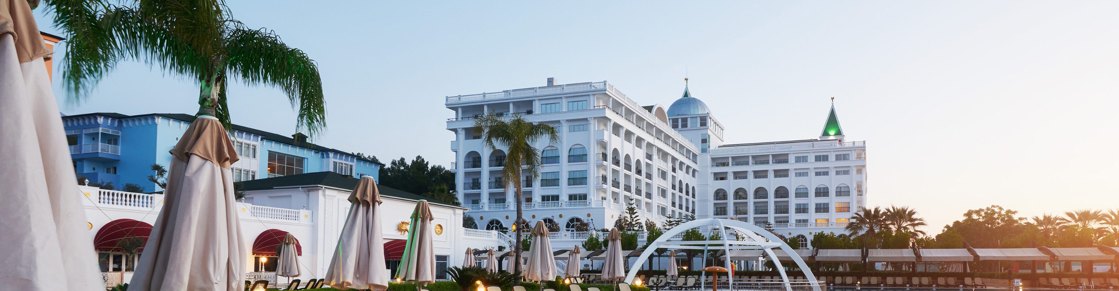 Resort hotel with palm trees and poolside umbrellas