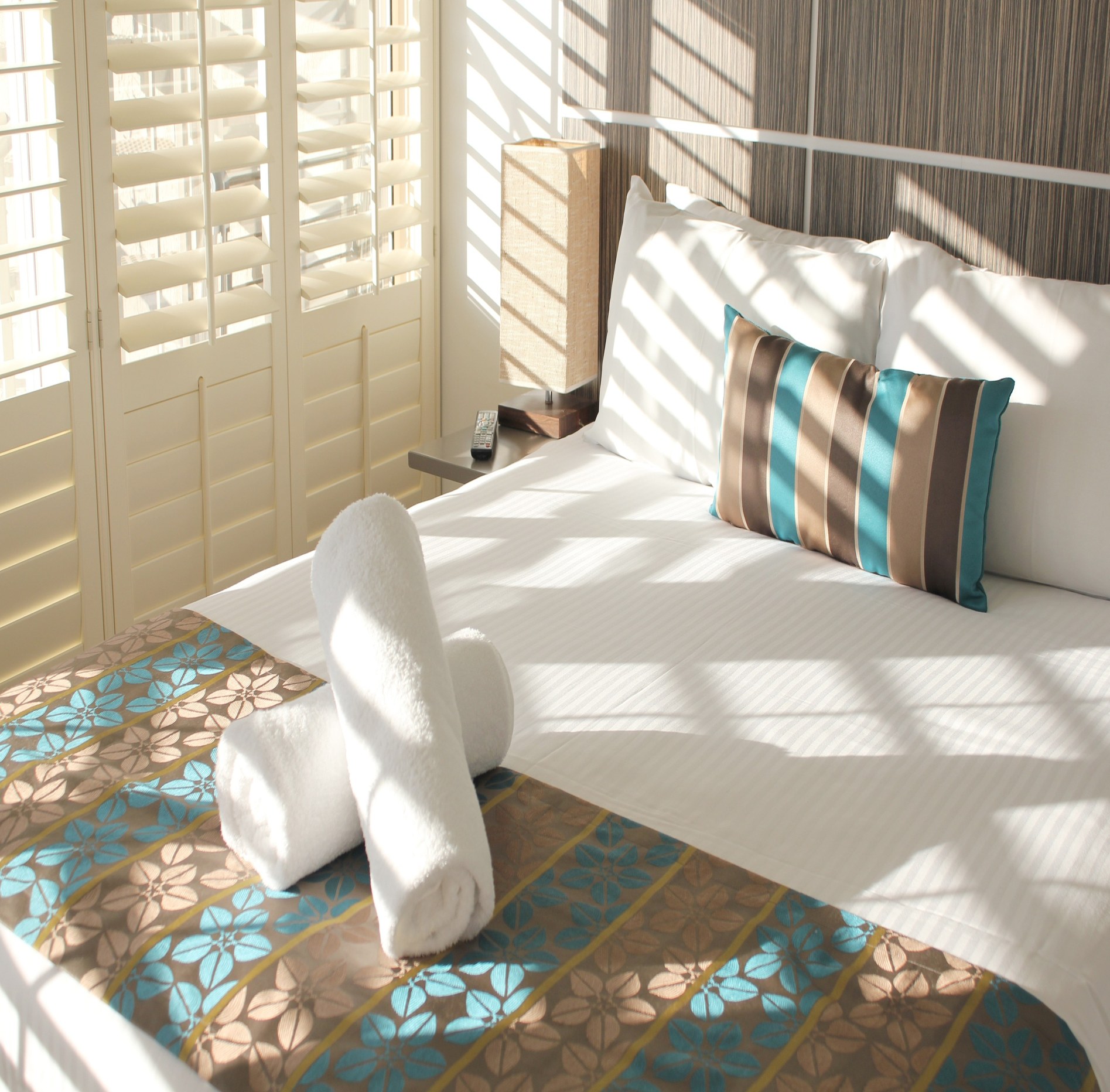 Resort bed with towels and coastal styling